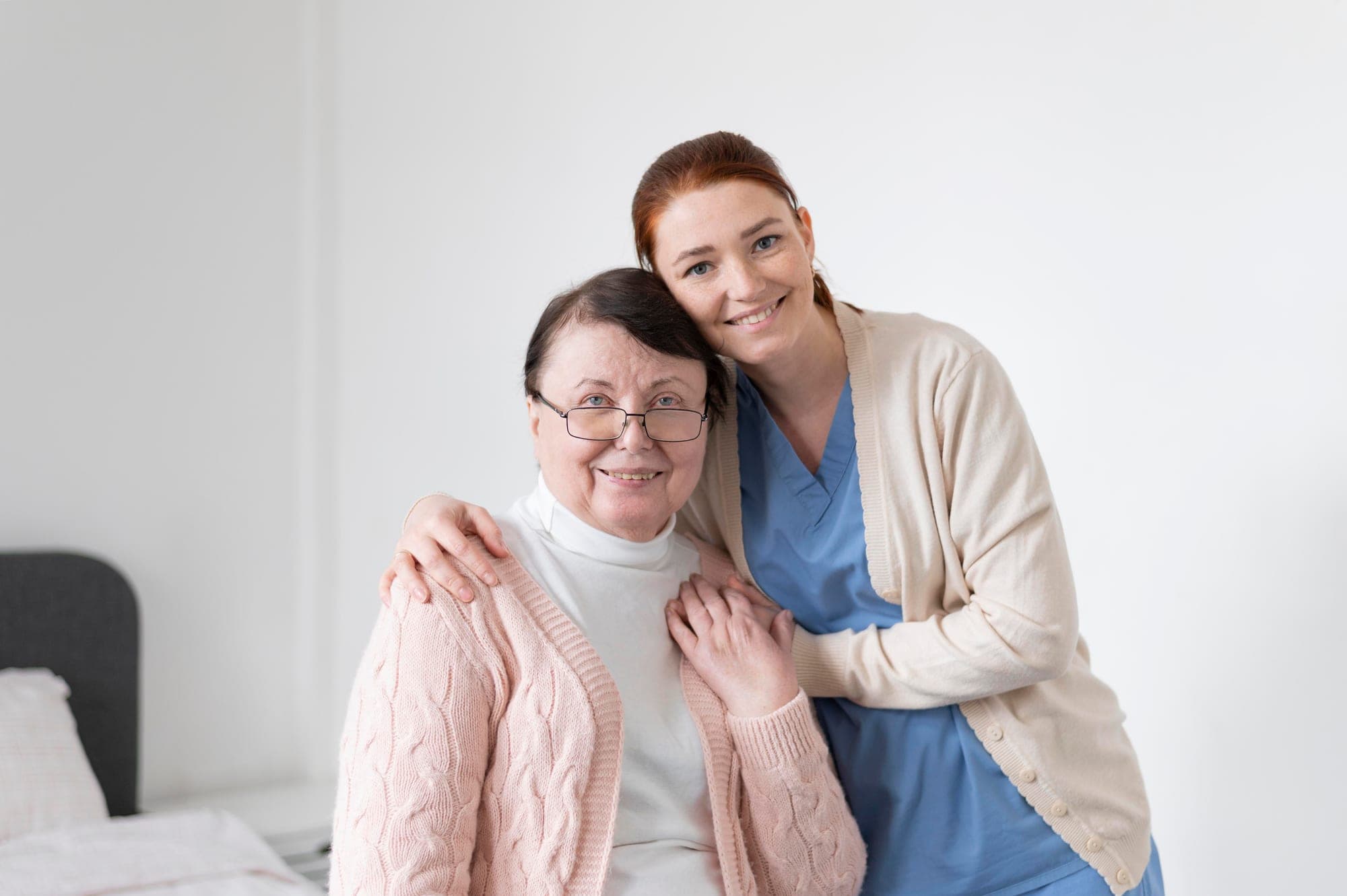 Une soignante entoure de son bras une résidente souriante